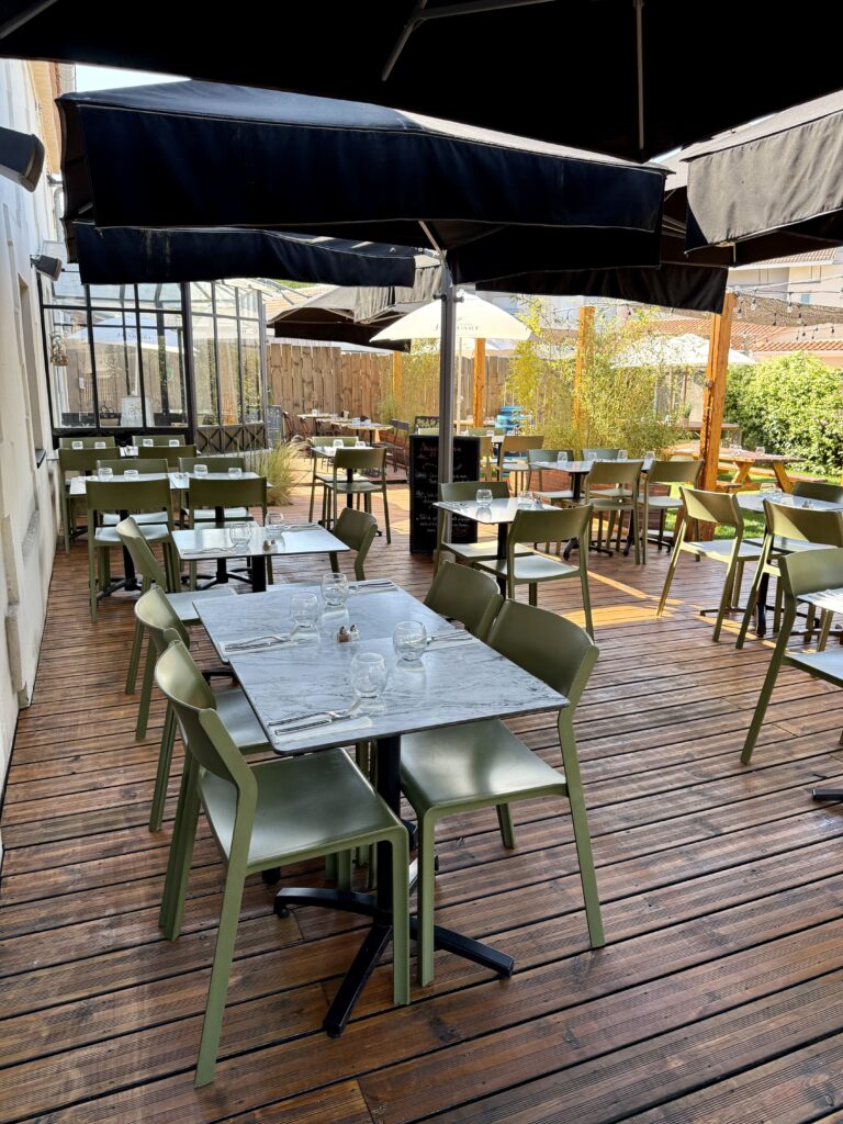 Vue sur la terrasse et le jardin, du restaurant Café Rostand, au Haillan