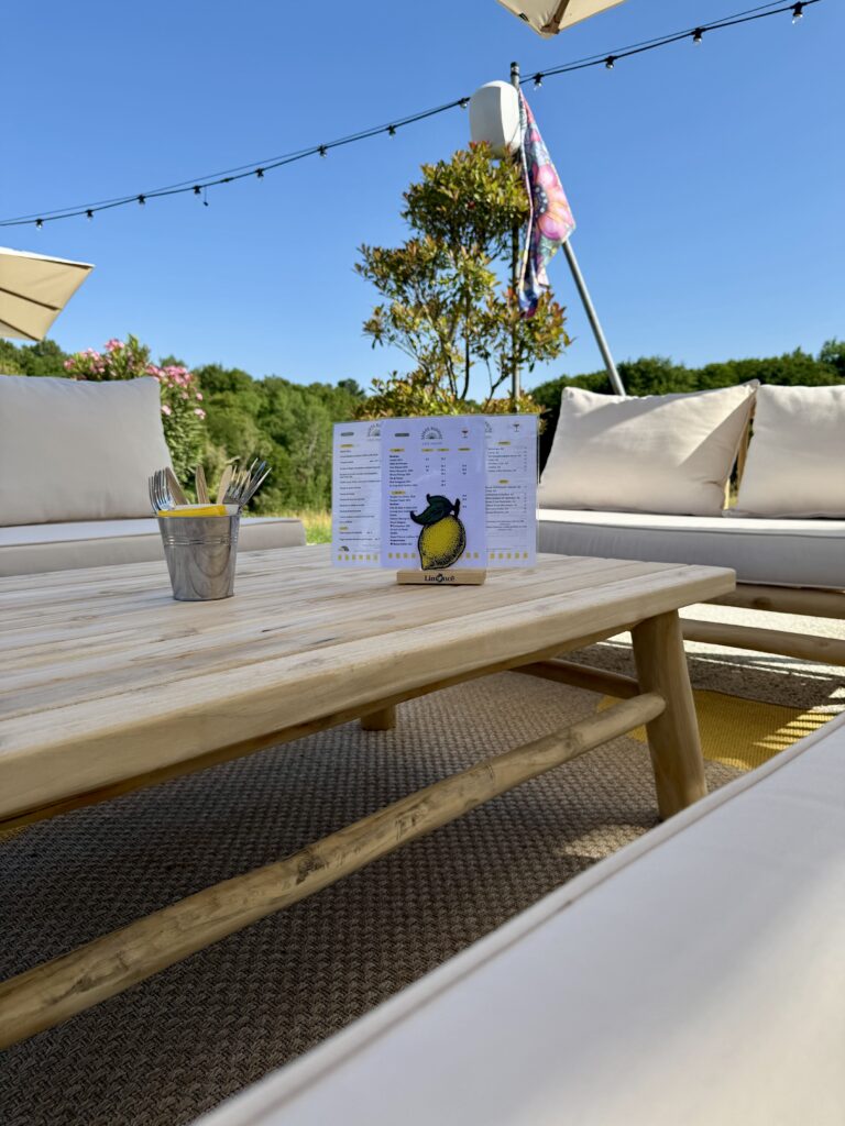 La carte et les canapés confortables de la terrasse guinguette, du Domaine Sainte-Raphine Coté Piscine, à Fargues-Saint-Hilaire