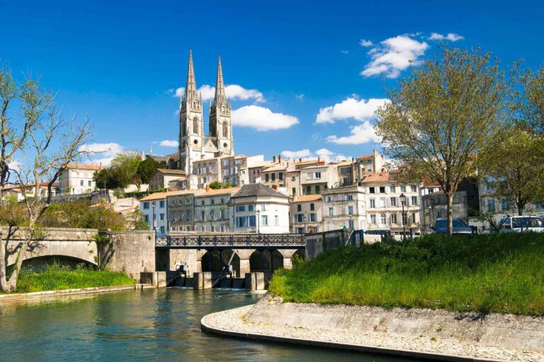 Une photo de la ville de Niort avec sa cathédrale et le canal