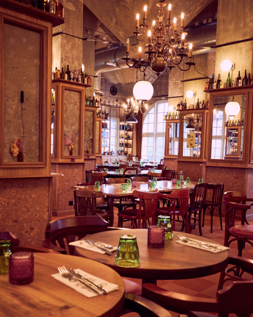 Salle de restaurant de Big Luck à Marquette-lez-Lille avec tables en bois et lustres
