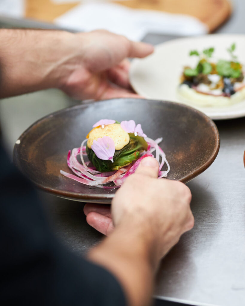 Assiette bistronomique dressée chez Bleu Canard à Lille avec légumes, sauce et fleurs comestibles
