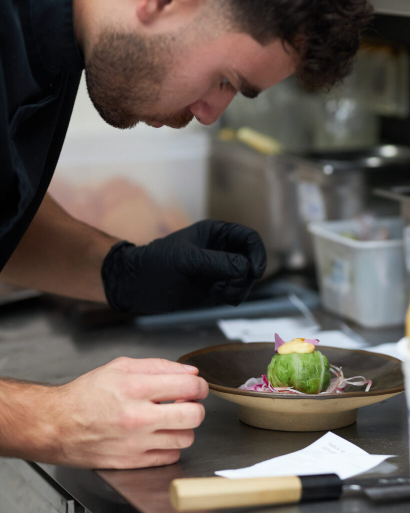 Chef en cuisine dressant une assiette bistronomique chez Bleu Canard à Lille