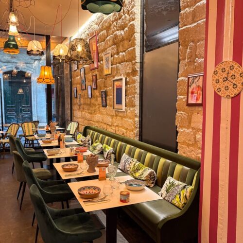 Vue sur la salle du restaurant, banquette, décoration chinée, murs en pierre du restaurant Disco Volante