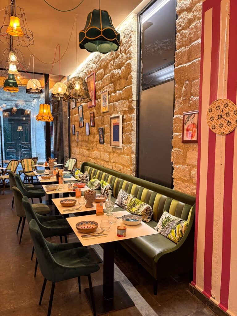 Vue sur la salle du restaurant, banquette, décoration chinée, murs en pierre du restaurant Disco Volante