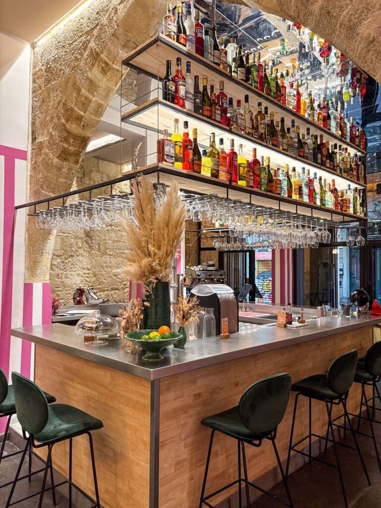 Bar et murs de spiritueux illuminé, tabourets pour déguster un délicieux cocktail au bar