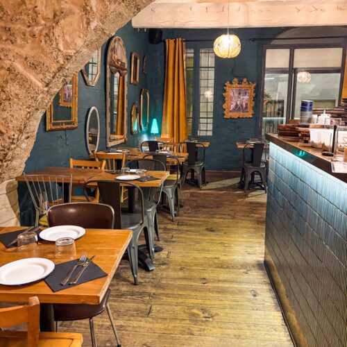 Une troisième salle du restaurant avec cuisine ouverte, ambiance chaleureuse et boisée, miroirs