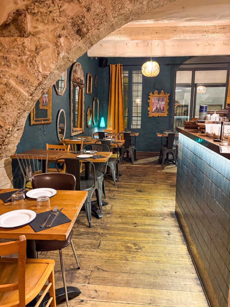 Une troisième salle du restaurant avec cuisine ouverte, ambiance chaleureuse et boisée, miroirs