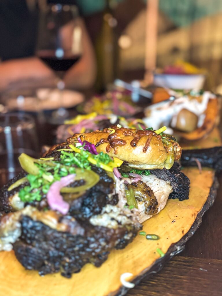 Un plat typique du restaurant servi sur planche, viande fumée et cheese bread