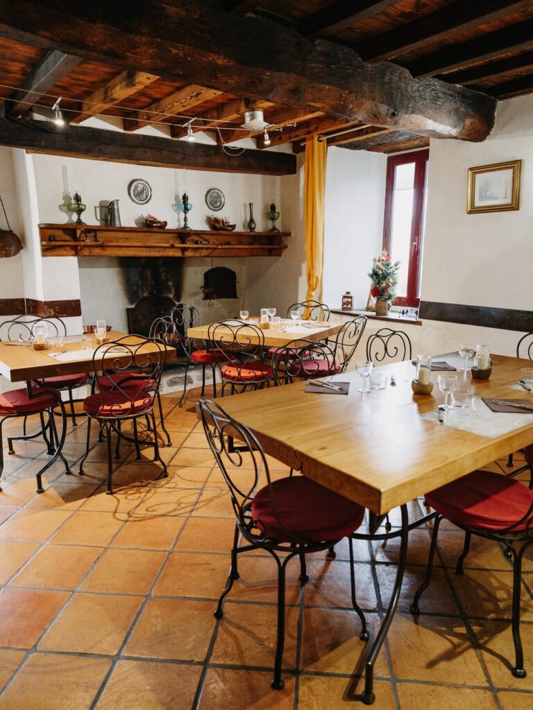 Tables en bois et chaises confortable d'un restaurant de type cuisine française de montagne à Arras-en-Lavedan près de Pau