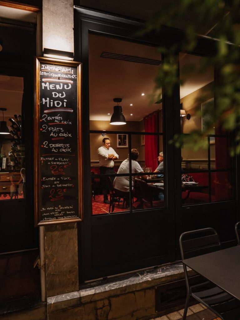 Chef qui parle avec ses clients vue de l'extérieur d'un restaurant de type cuisine française à Tarbes, près de Pau