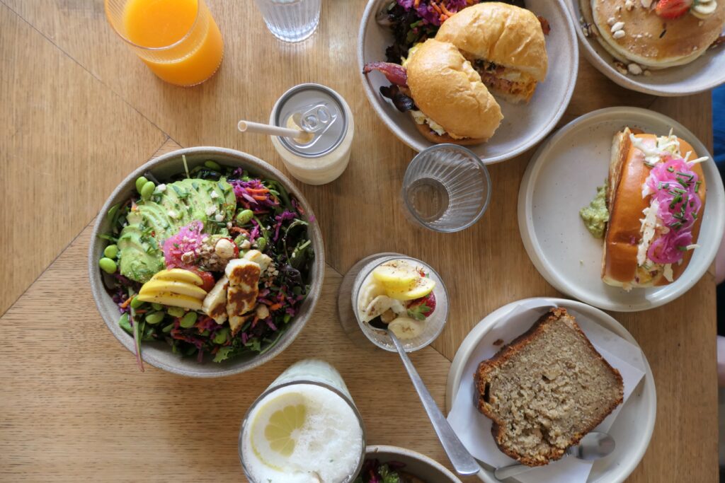 Table garnie des plats sucrés et salés à la carte du restaurant de brunch et coffee shop Popette Brunch à Arcachon.