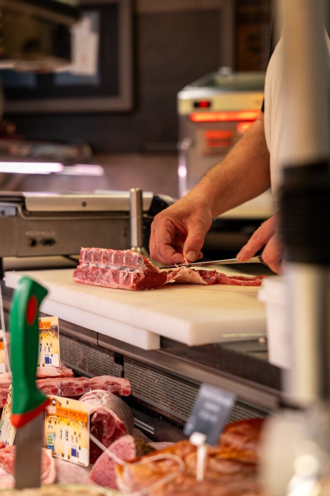 Un boucher de La Boucherie Moderne à Saint-Malo en pleine découpe