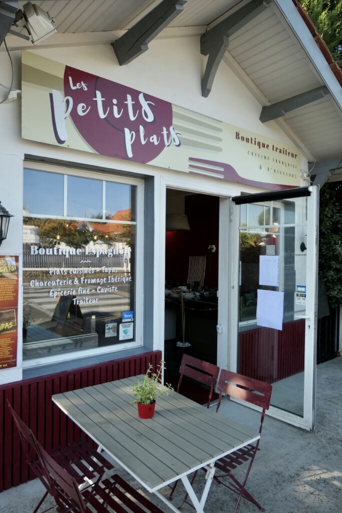 Devanture et table extérieure du traiteur Les Petits Plats à la Hume, quartier de Gujan-Mestras.