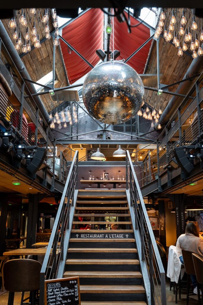 Escalier bois et métal sous boule disco au Dock à Saint-Malo.