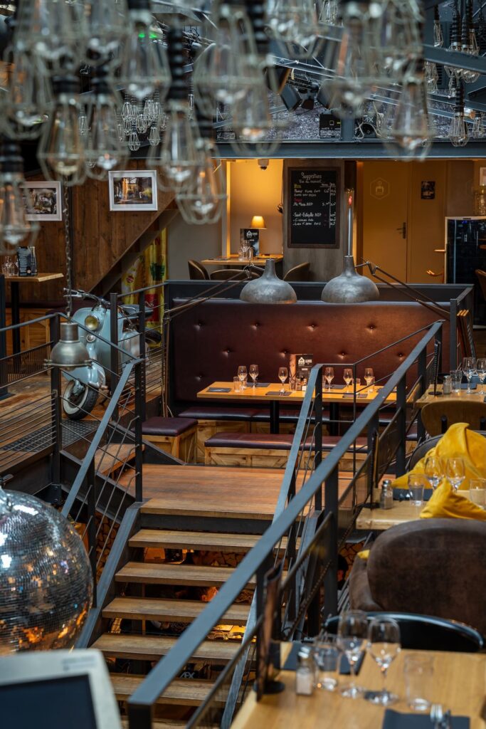 Ambiance industrielle avec tables et luminaires au Dock à Saint-Malo.