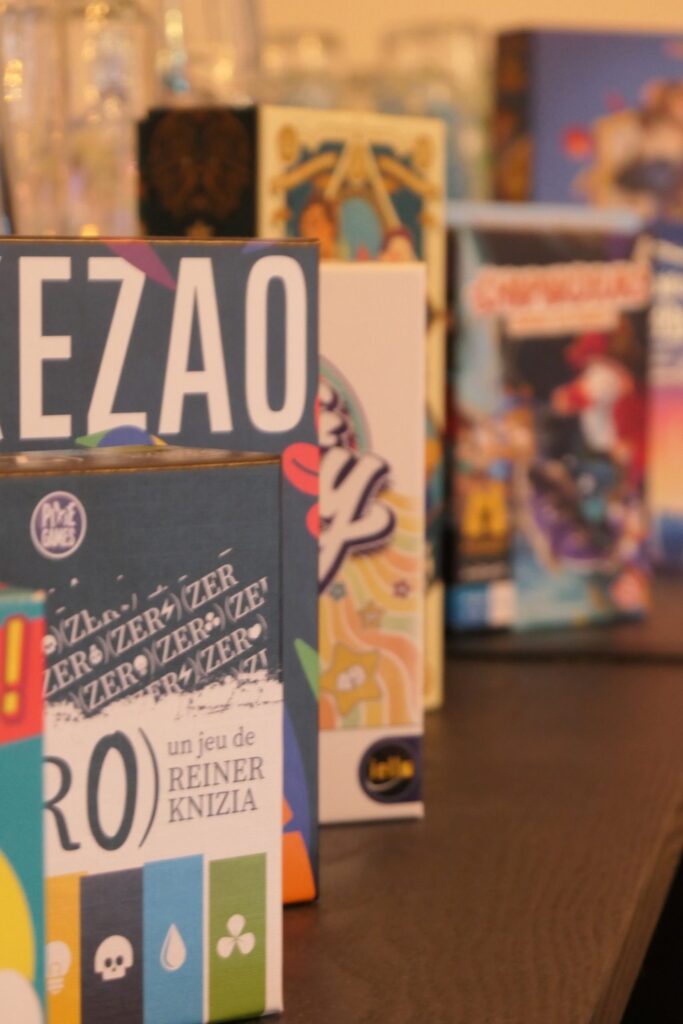 Boîtes de jeux de société à disposition au bar à jeux Le Shifumi, à La Teste-de-Buch.
