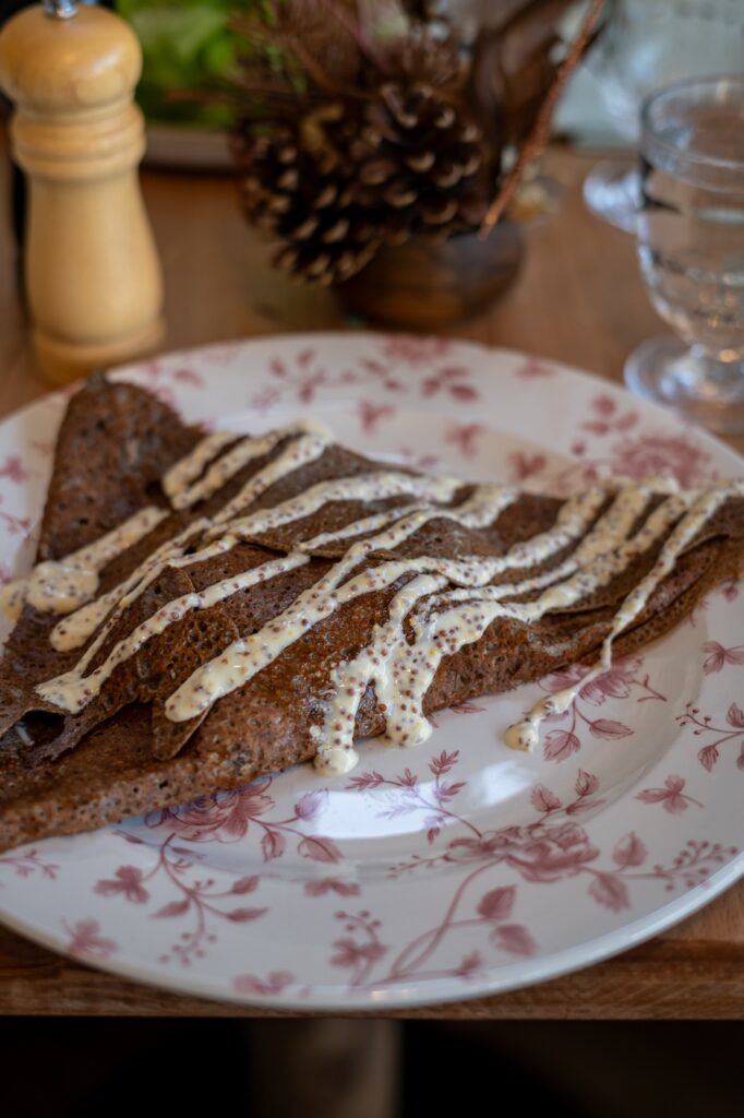 Galette saucisse bretonne avec confit d’oignons et moutarde à l’ancienne à la Crêperie Suzette à Dinan.