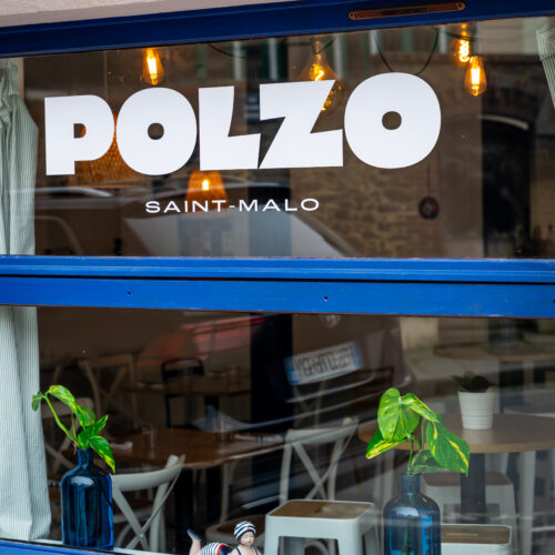 Logo blanc et bleu sur la vitrine de Polzo à Saint-Malo.