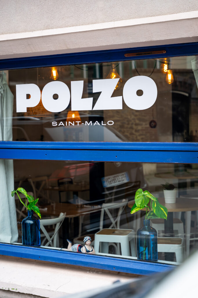Logo blanc et bleu sur la vitrine de Polzo à Saint-Malo.