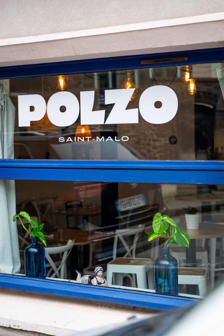 Logo blanc et bleu sur la vitrine de Polzo à Saint-Malo.
