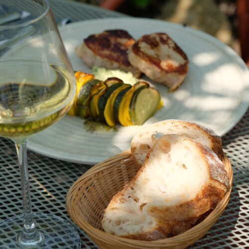 Plat à l'ardoise viande et légumes rotis sur une table en terrasse