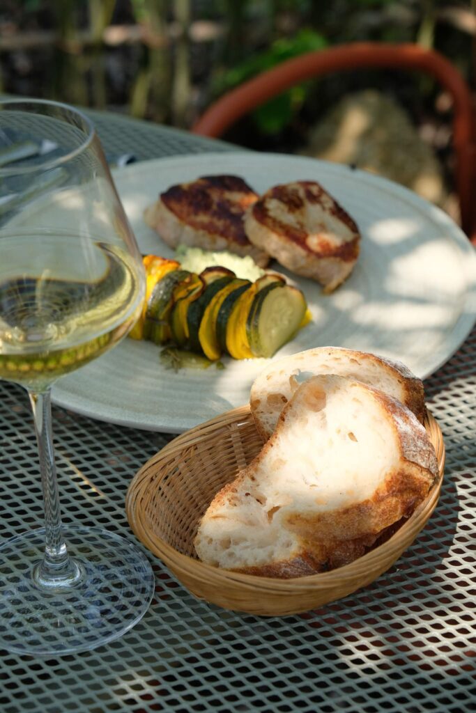 Plat à l'ardoise viande et légumes rotis sur une table en terrasse