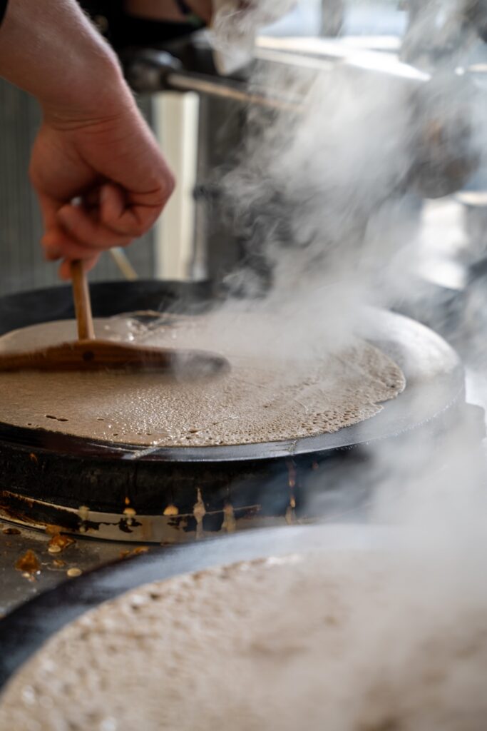 Une galette en cours de préparation sur le billig par Rodolphe, de Maître Sarrasin à Saint-Malo