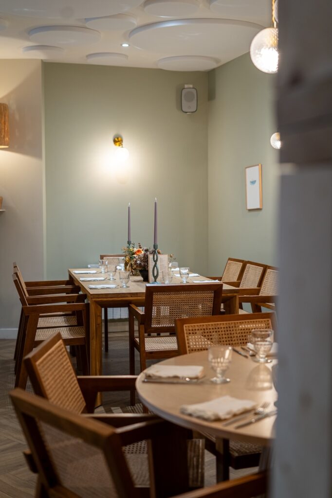 Décor soigné avec mur vert d’eau et luminaires modernes à la Crêperie Suzette à Dinan.