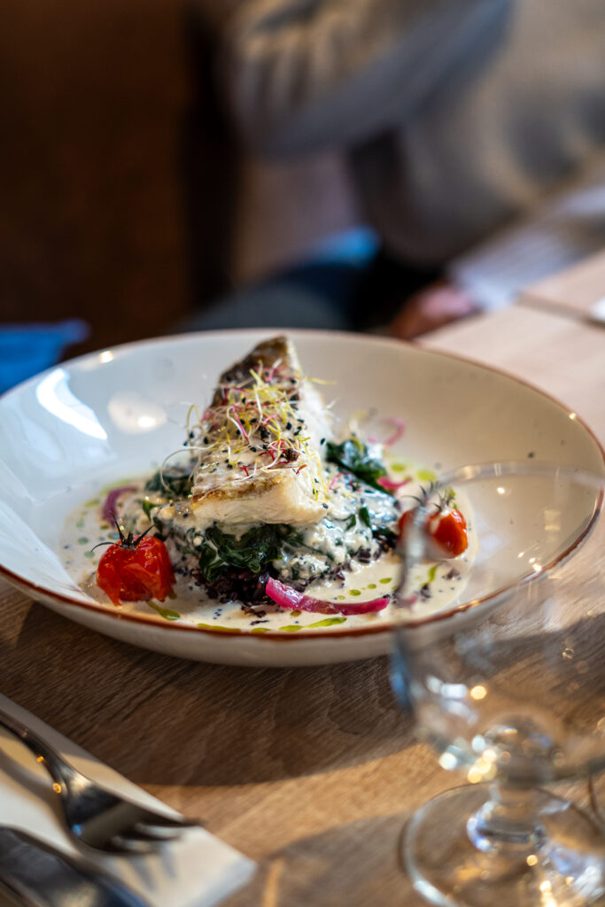 Plat raffiné pavé de lieu jaune et épinards et son beurre blanc au restaurant L'Amateur à Saint-Malo.