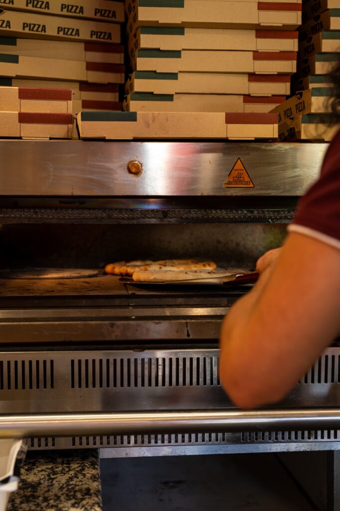 Des pizzas artisanales cuisent dans le four pour un goût authentique et généreux. Gioia, Saint-Malo.