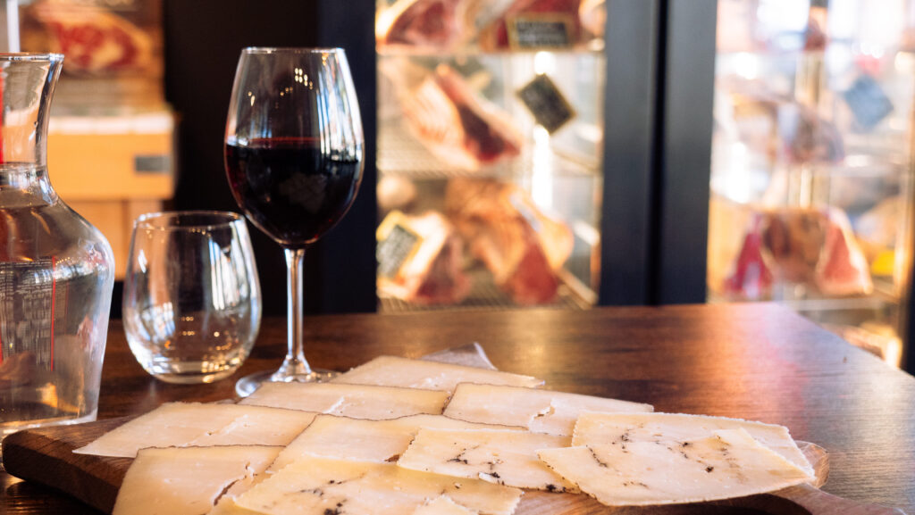 Verre de vin et planche de fromage manchego truffé au restaurant Le Bellota à La Teste-de-Buch.