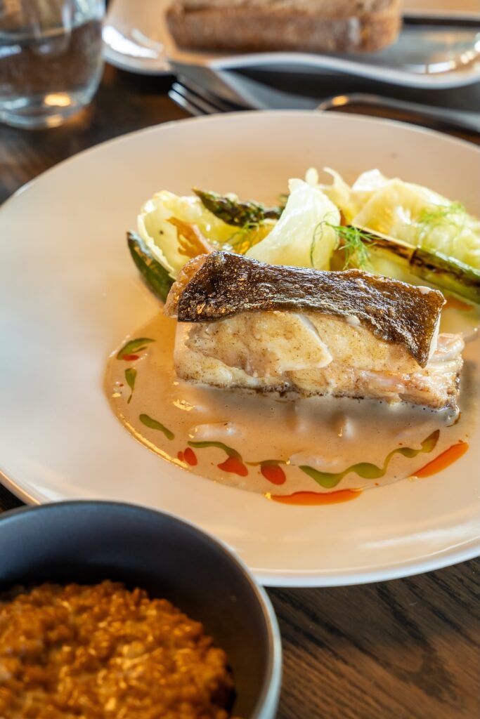 Plat de poisson avec sauce et légumes au Le 5 Restaurant à Saint-Malo.