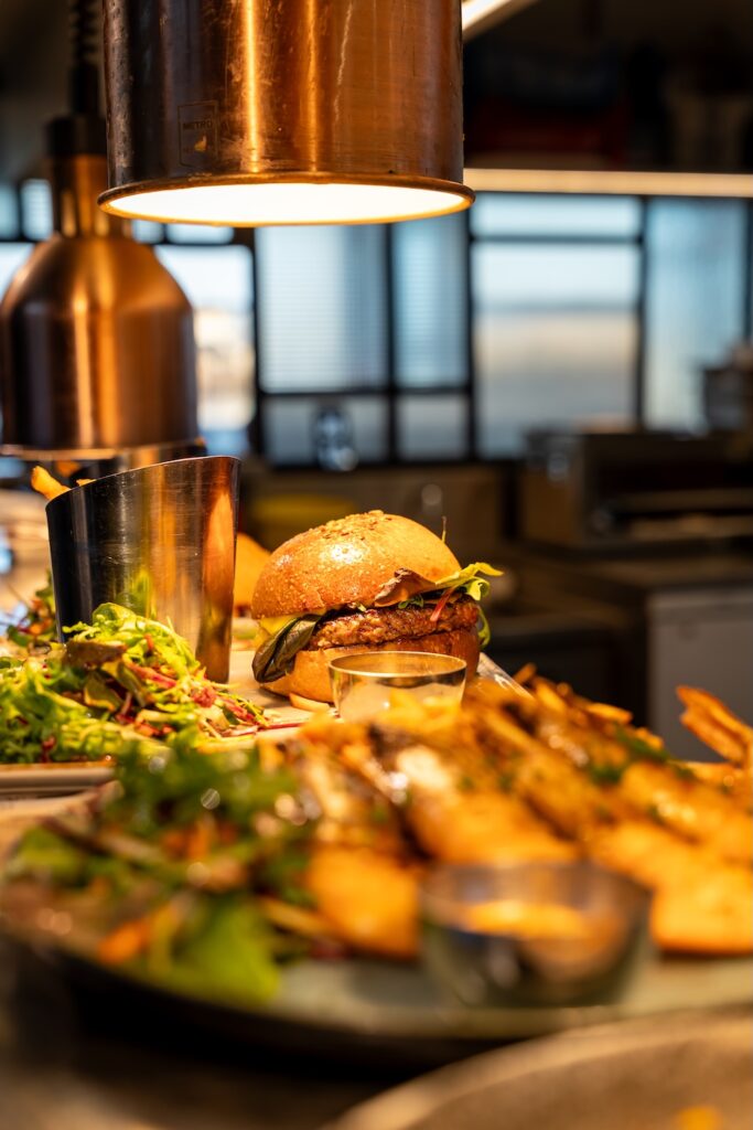 Assiettes dressées en cuisine. Prêtes à être envoyées dont un burger au 1934 à Saint-Malo.