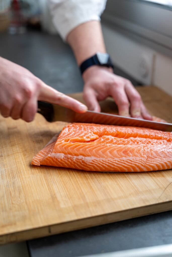 Valentin, chef de Popote à Saint-Malo, en train de découper un pavé de Saumon