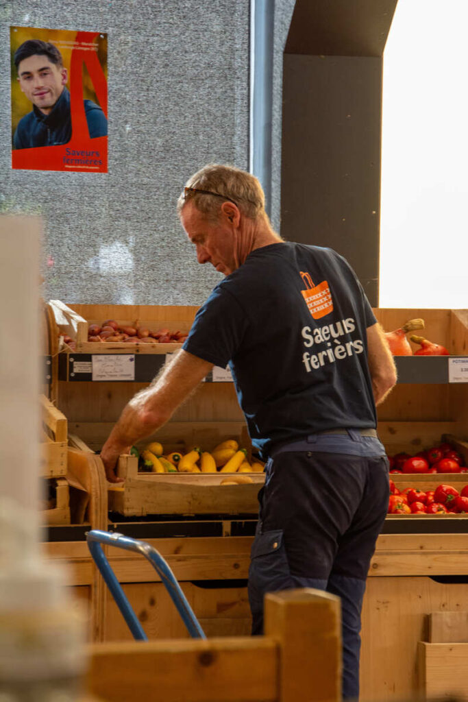 Un boulanger qui met son pain en place à Saveurs Fermières, coopérative de producteur à Limoges