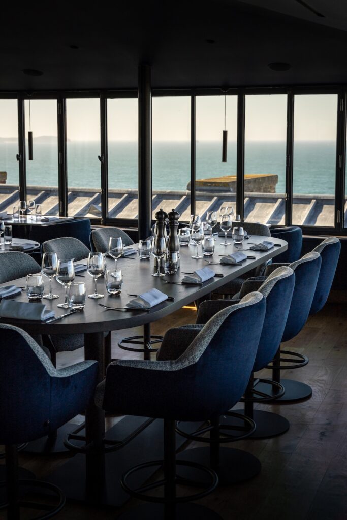Salle lumineuse avec grande tablée et vue mer au Le 5 Restaurant à Saint-Malo.