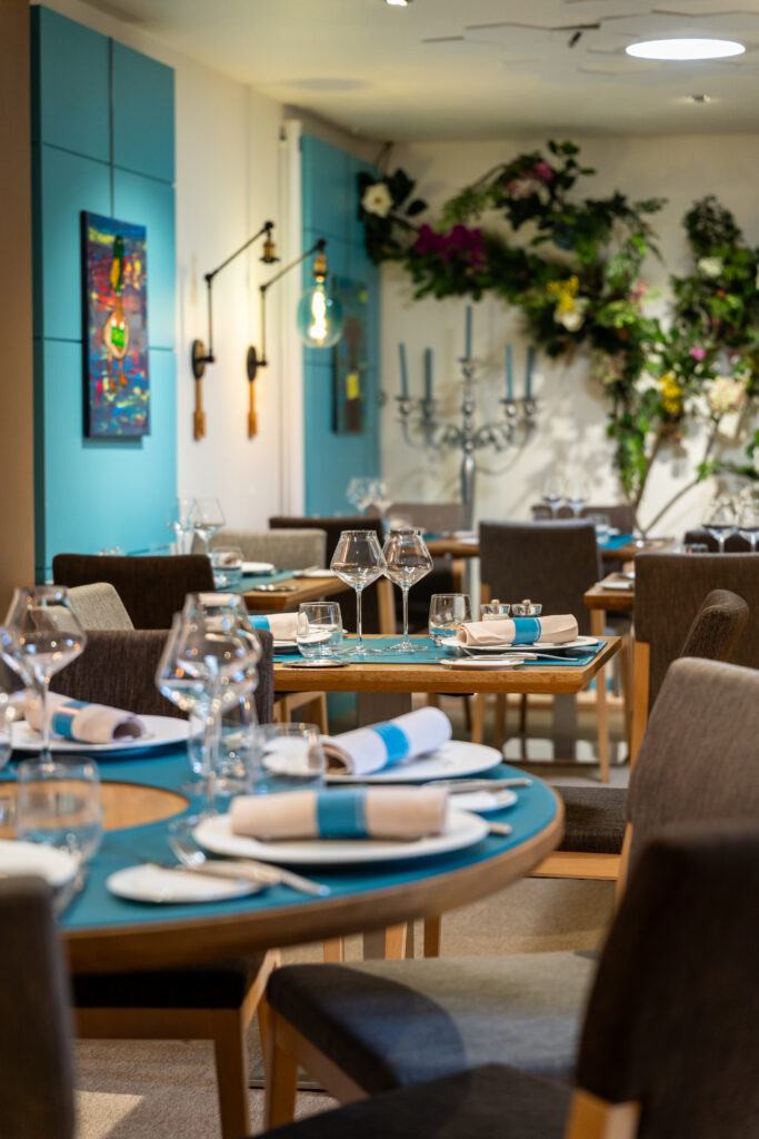 Salle lumineuse aux tons blanc et bleu turquoise à L'Auberge du Pélican à Dinan.