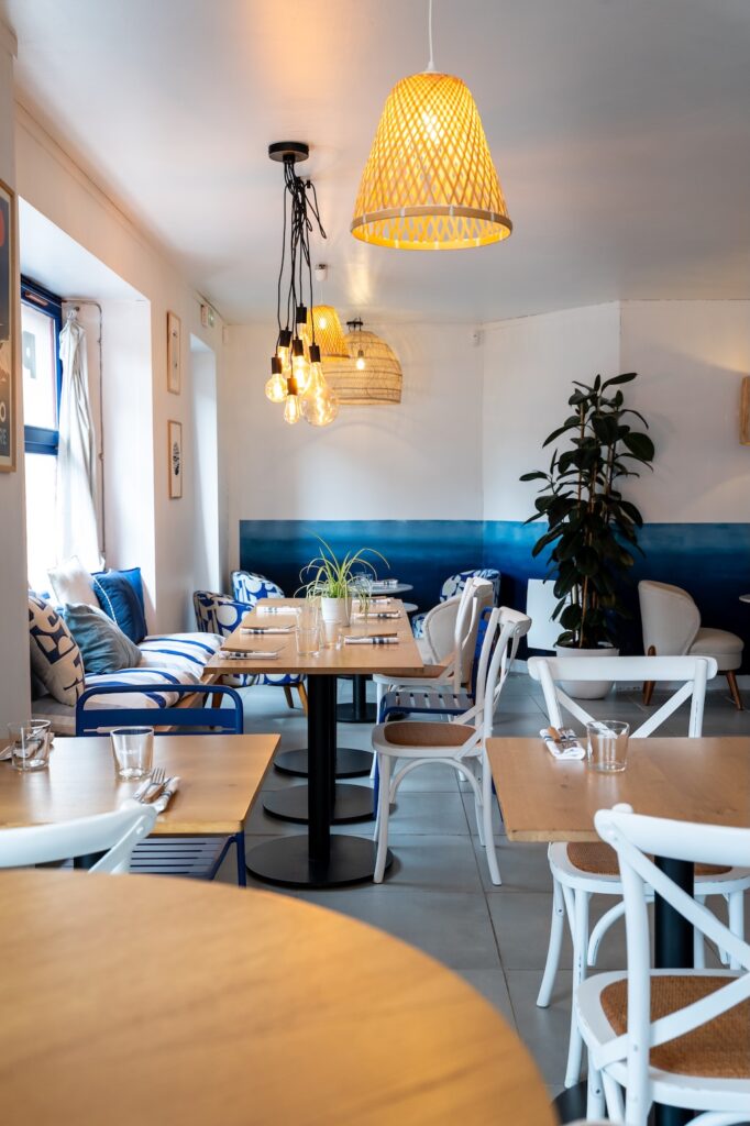 Salle élégante avec mobilier blanc et bois aux murs blanc et bleu à Polzo à Saint-Malo