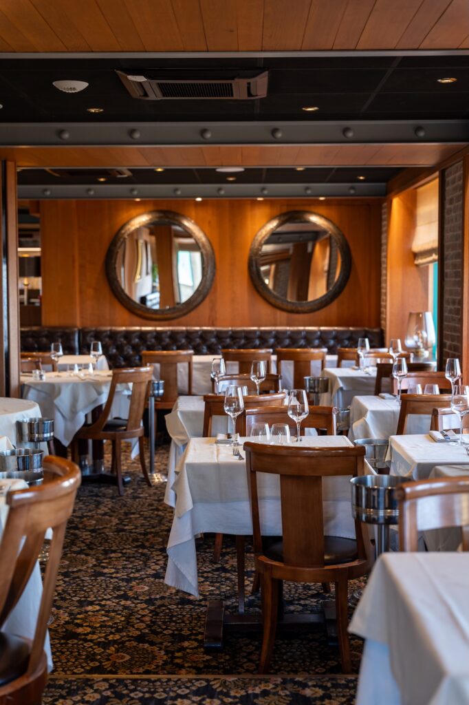 Salle en bois avec nappes blanches à la Brasserie du Sillon à Saint-Malo.