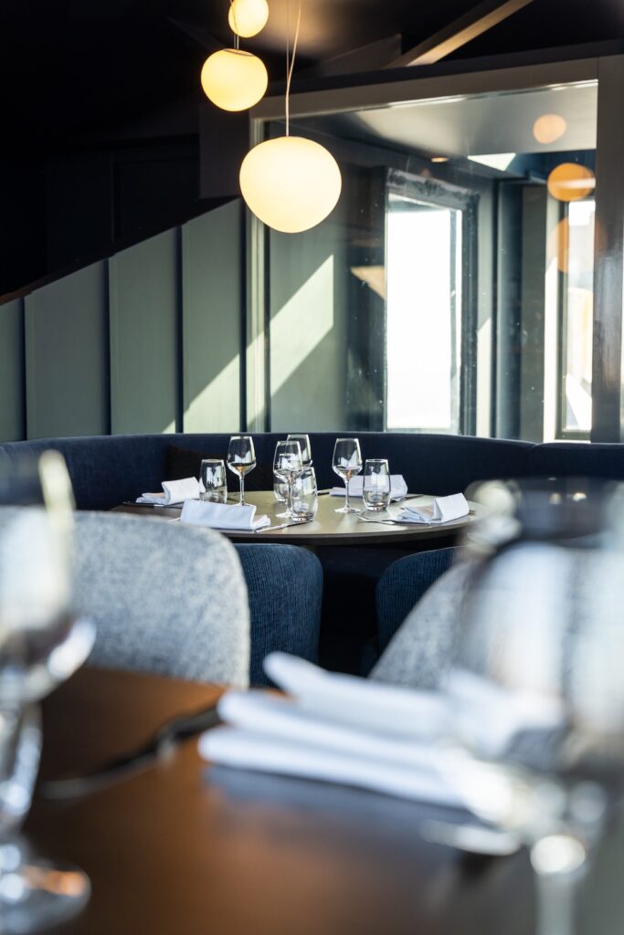 Intérieur lumineux avec tables prêtes à accueillir les clients au Le 5 Restaurant à Saint-Malo.