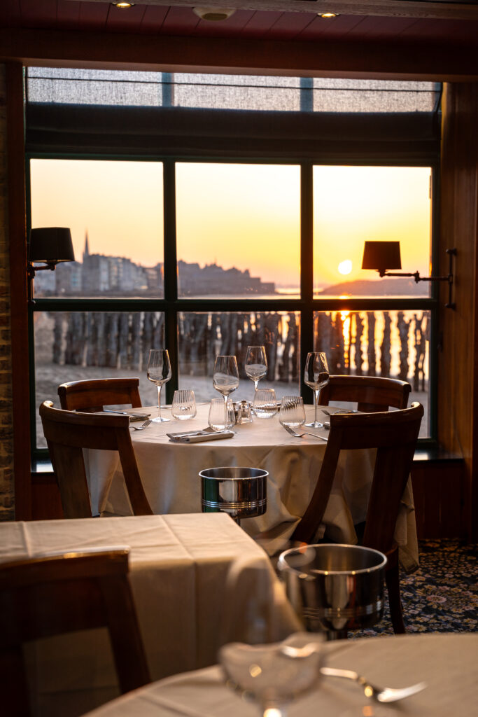 Table dressée face à la mer et au coucher de soleil à la Brasserie du Sillon à Saint-Malo.
