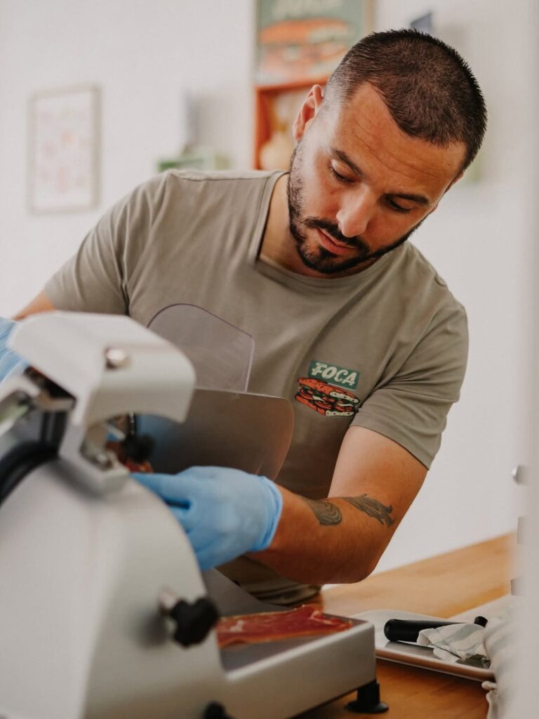 Chef qui coupe lui-même son jambon d'une sandwicherie de type cuisine italienne à Pau, près de Tarbes