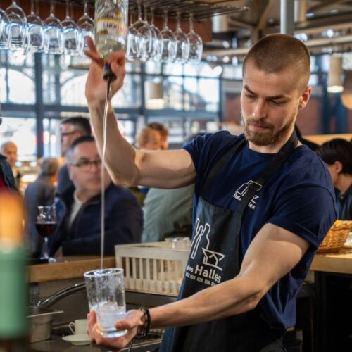 un serveur en train de servir un cocktail à l'îlot des halles en plein coeur des halles centrales de Limoges dans le centre ville