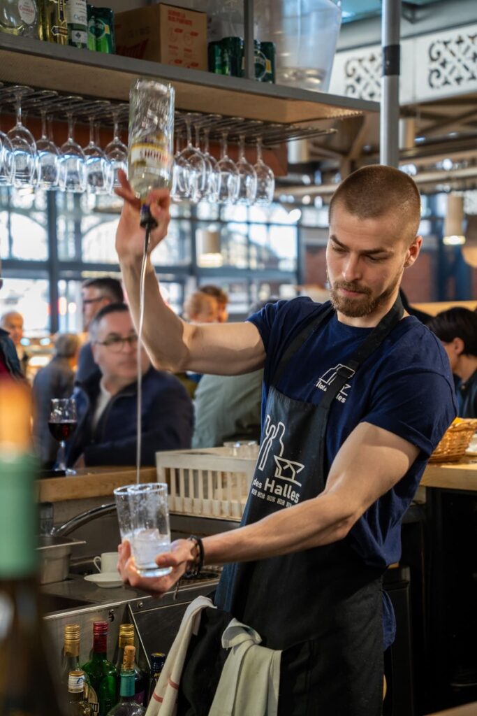 un serveur en train de servir un cocktail à l'îlot des halles en plein coeur des halles centrales de Limoges dans le centre ville