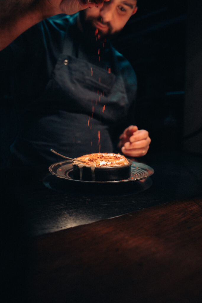 Giovanni, le cuisinier, du restaurant De Part et d'Autre, situé à Bordeaux, en train de préparer un camembert rôti