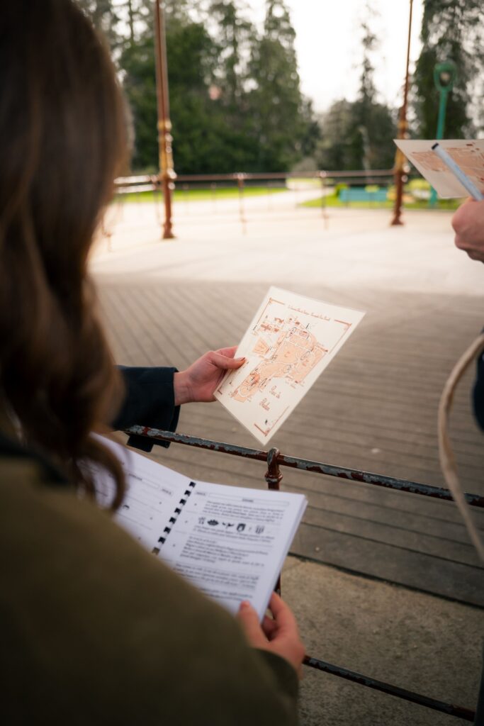 Des joueurs qui enquêtent lors d'un escape game extérieur d'Enquêtes Passe-Muraille