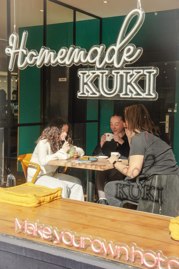 vue interieur de gokuki en etant a l'exterieur, amies en train de dejeuner et prendre un cafe ensemble