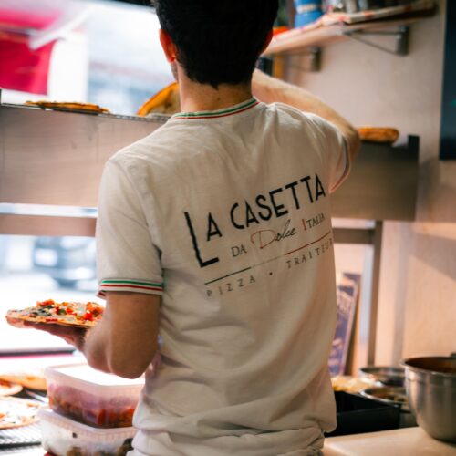 Un pizzaïolo de La Casetta, à Rennes, préparant des pizzas fraîches.