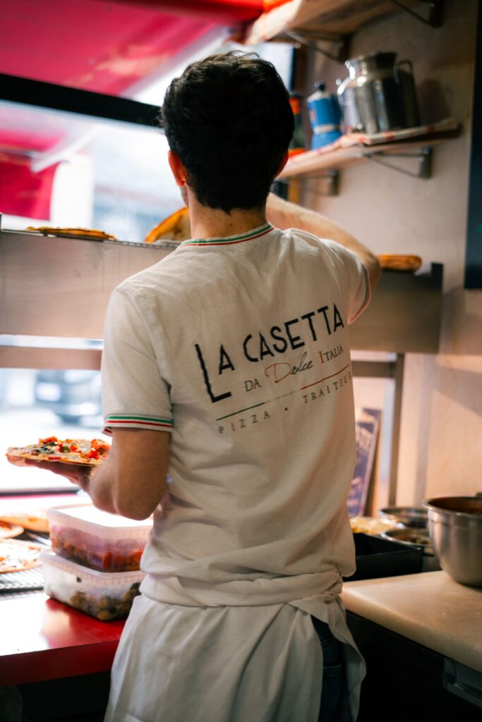 Un pizzaïolo de La Casetta, à Rennes, préparant des pizzas fraîches.