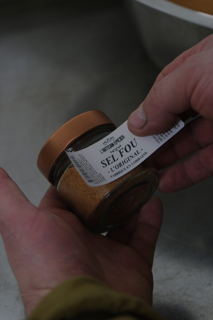 collage de l'étiquette lors de la mise en pot du mélange d'épices
